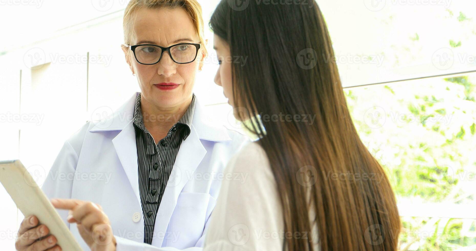 Asian woman patient sitting with doctor about her illness and showing x-ray results photo