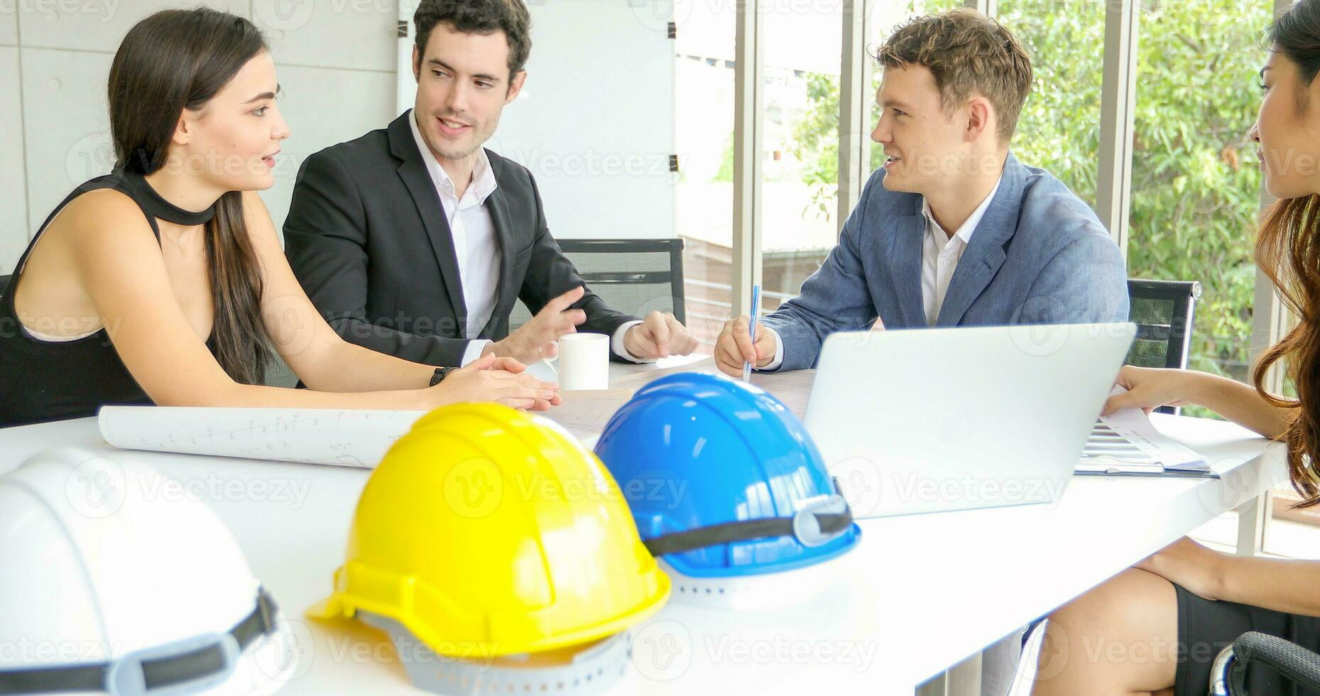 Diverse group of engineers, technicians, and specialists on meeting analyze technical drafts and hardhat presenting blueprint to business people in office photo