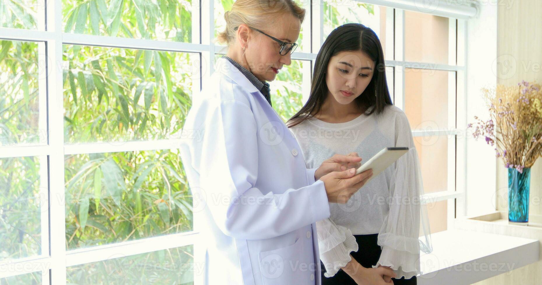 Asian woman patient sitting with doctor about her illness and showing x-ray results photo