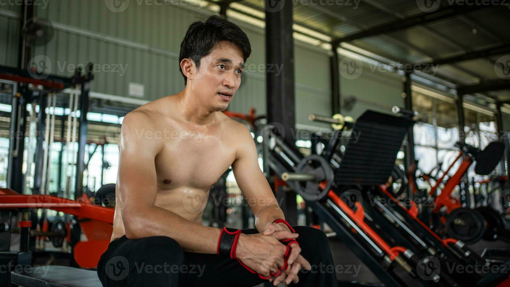 young men resting after an intensive workout in the gym. Fitness healthy man tired after a strength training exercise at the gym. photo