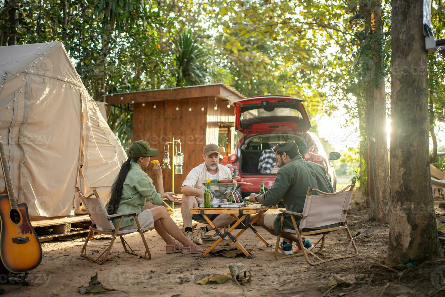 Group tourists drinking beer-alcohol and play guitar together with enjoy and happiness in Summer while camping photo