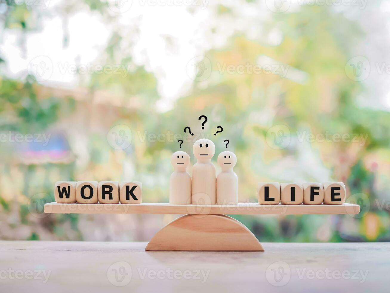 Wooden human figure with question marks. The choice between work and life. photo