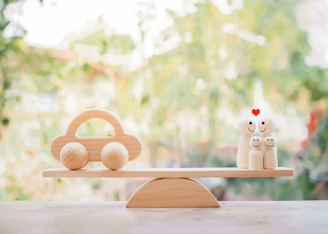 Wooden toy car and wooden figure of family on balancing scale. The concept of saving money buy a car in the future for family. photo