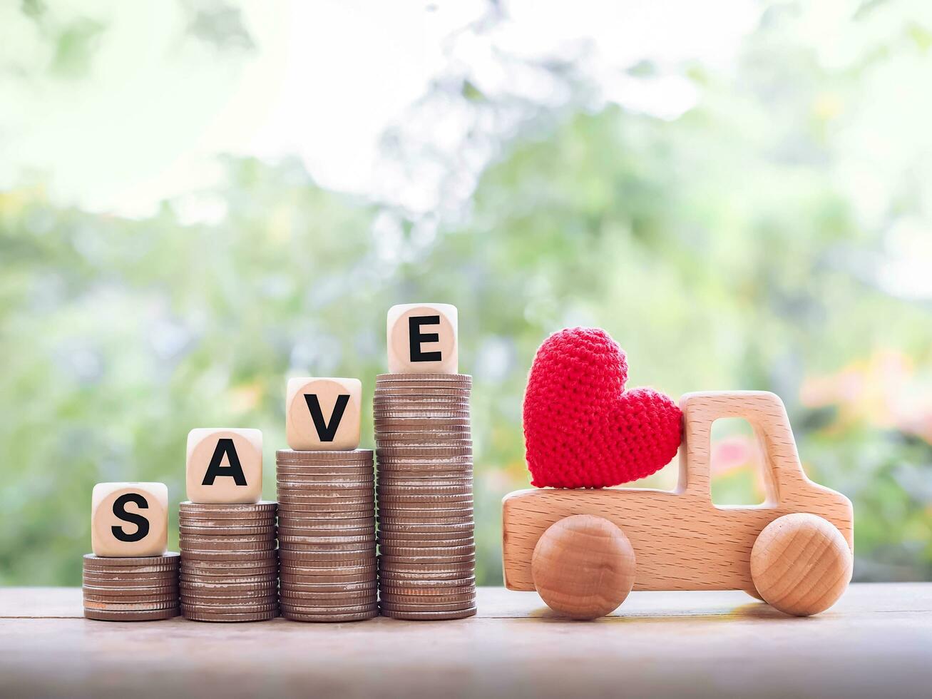 rojo corazón en de madera juguete auto, de madera bloques con el palabra salvar en apilar de monedas el concepto de ahorro dinero comprar un coche en el futuro. foto