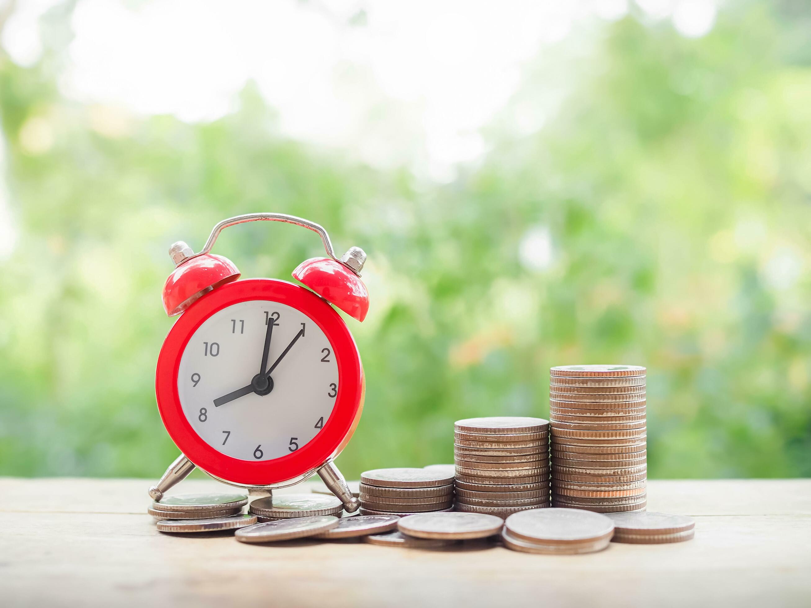 Time is money concept. Red alarm and stack of coins. Save money for