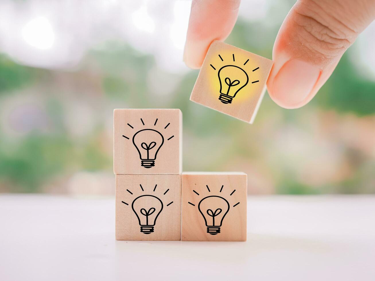 Close up hand arranging wooden block with light bulb for leadership, creative, idea, innovation concept. photo