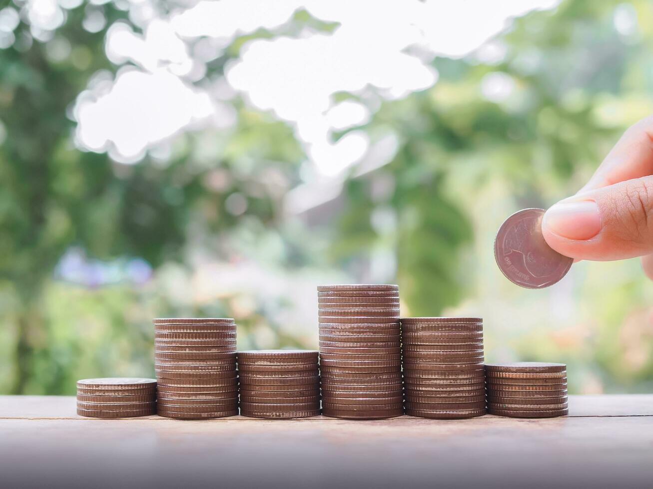 Close up hand putting coin in stack of coins, The concept of save money for prepare in the future. photo