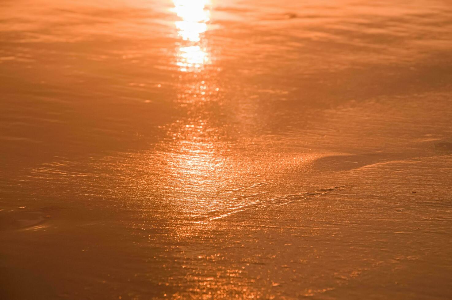 Water and sand at the beach in sunset time photo