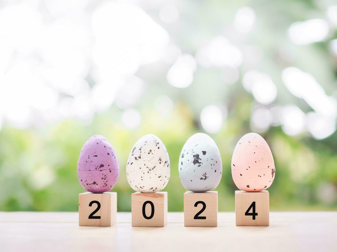 Easter eggs on wooden block with number 2024 for EASTER DAY in new year