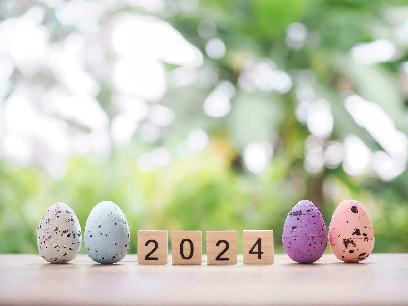 Easter eggs and wooden block with number 2024 for EASTER DAY in new year 2024 concept. photo