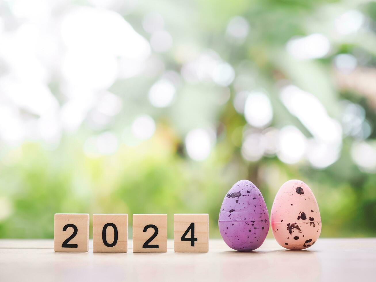 Easter eggs and wooden block with number 2024 for EASTER DAY in new year 2024 concept. photo