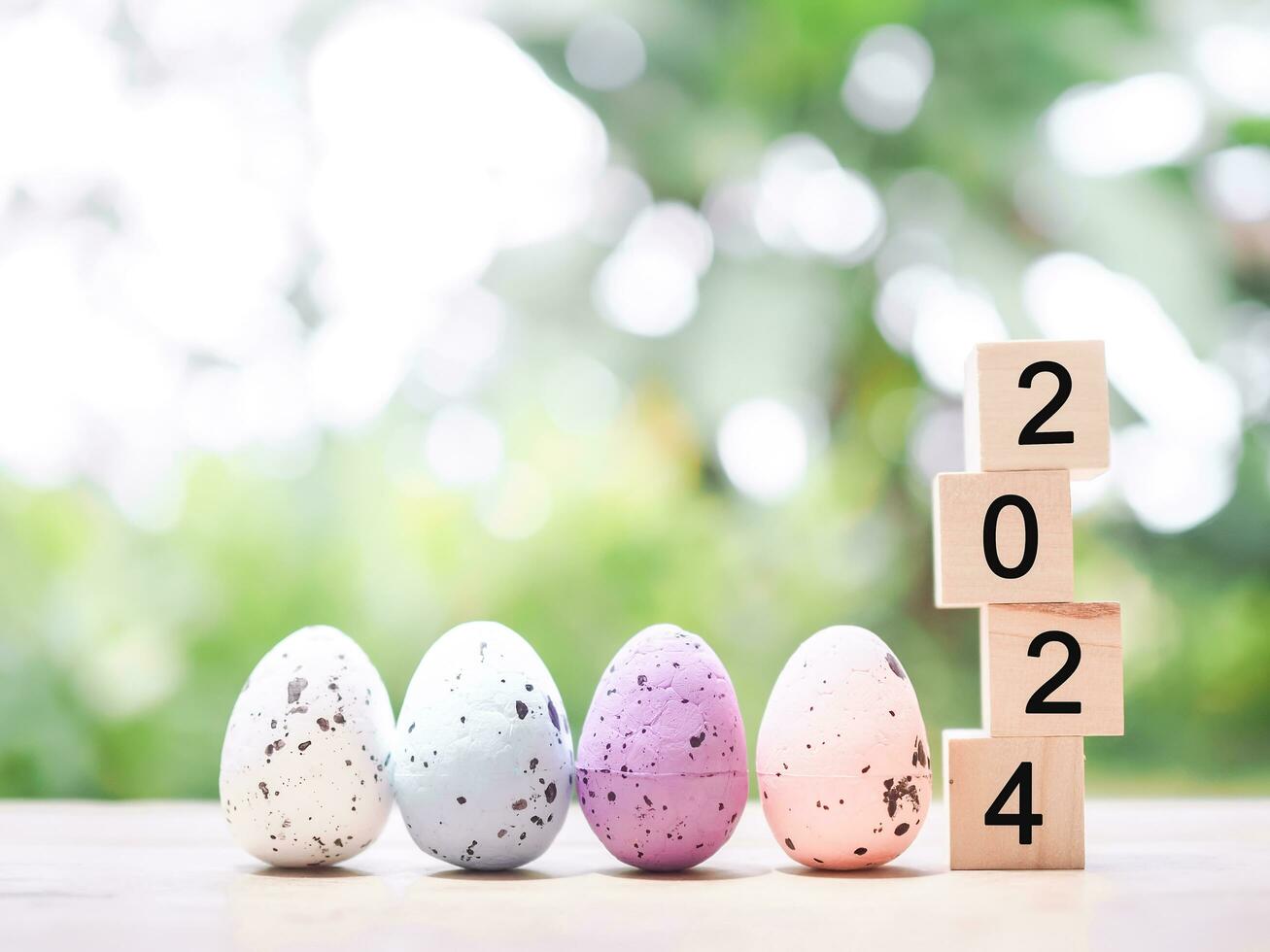 Easter eggs and wooden block with number 2024 for EASTER DAY in new year 2024 concept. photo