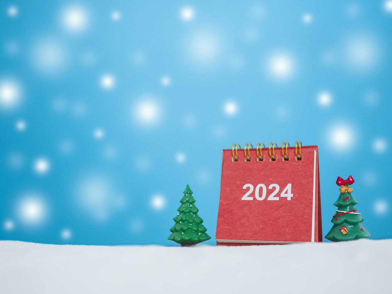 Close up calendar and christmas trees with shiny light for New Year and Christmas 2024 concept. photo