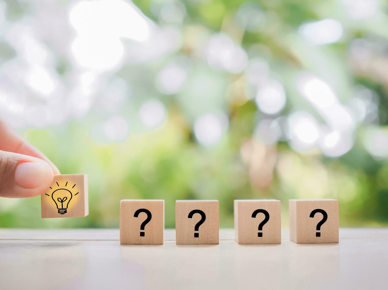 Close up hand arranging wooden block with light bulb and wooden block with question mark for leadership, creative, idea, innovation concept. photo
