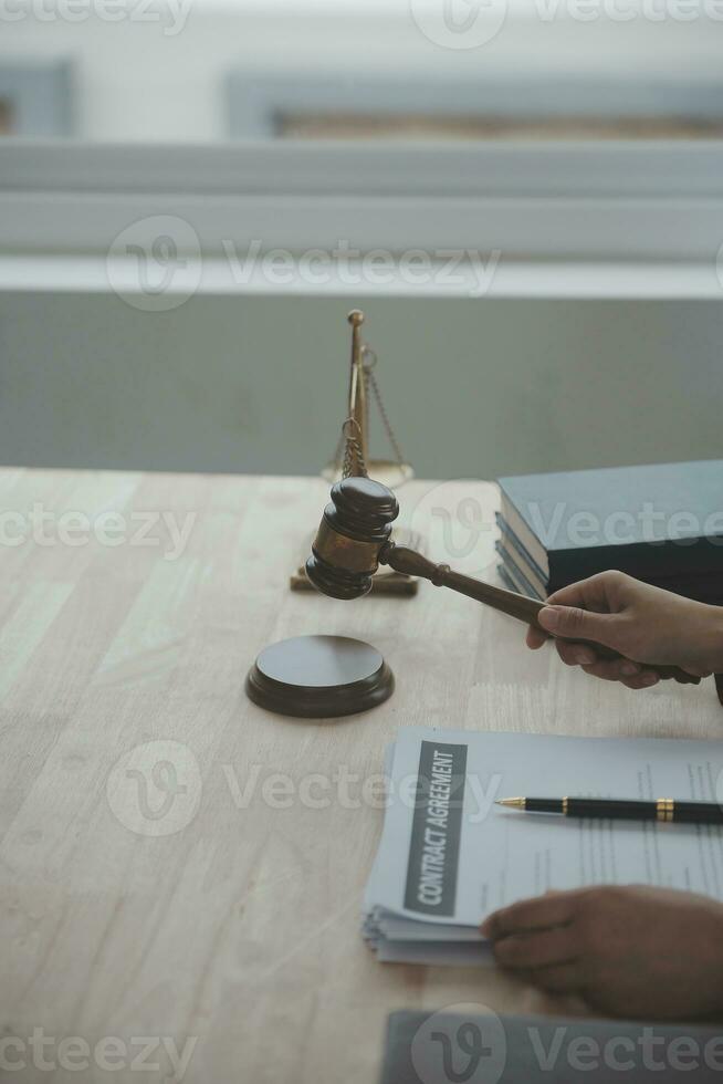 Business and lawyers discussing contract papers with brass scale on desk in office. Law, legal services, advice, justice and law concept picture with film grain effect photo