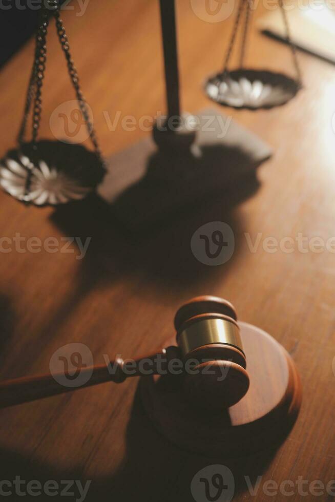Business and lawyers discussing contract papers with brass scale on desk in office. Law, legal services, advice, justice and law concept picture with film grain effect photo