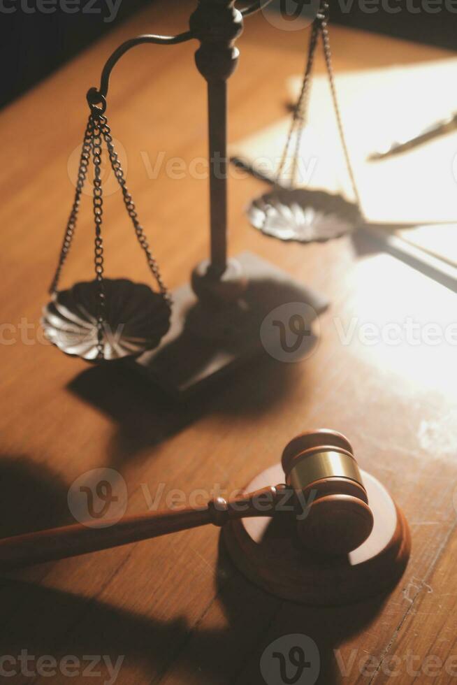 Business and lawyers discussing contract papers with brass scale on desk in office. Law, legal services, advice, justice and law concept picture with film grain effect photo