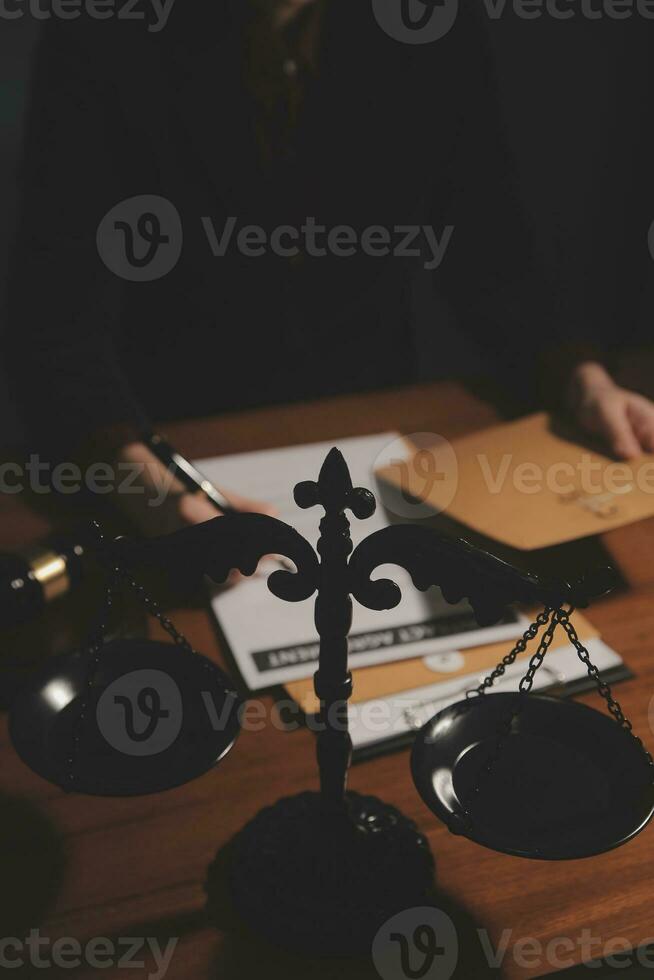 Business and lawyers discussing contract papers with brass scale on desk in office. Law, legal services, advice, justice and law concept picture with film grain effect photo