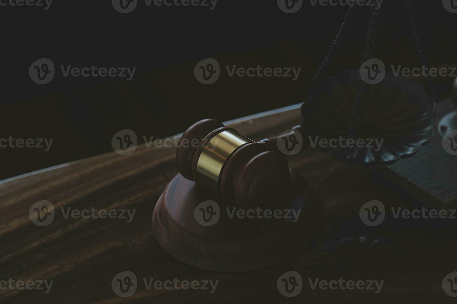 Justice and law concept.Male judge in a courtroom with the gavel, working with, computer and docking keyboard, eyeglasses, on table in morning light photo