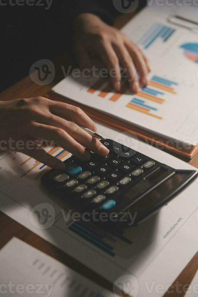 Close up businessman hand using calculator and working with laptop calculate about finance accounting at coffeeshop outdor.finance accounting concept photo