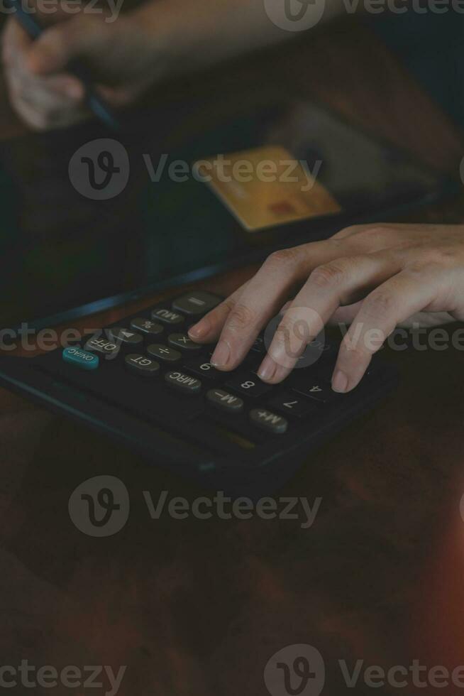 Close up businessman hand using calculator and working with laptop calculate about finance accounting at coffeeshop outdor.finance accounting concept photo