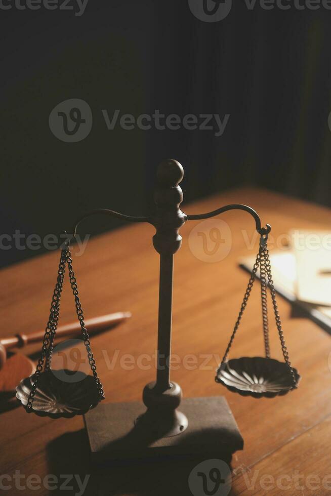 Business and lawyers discussing contract papers with brass scale on desk in office. Law, legal services, advice, justice and law concept picture with film grain effect photo