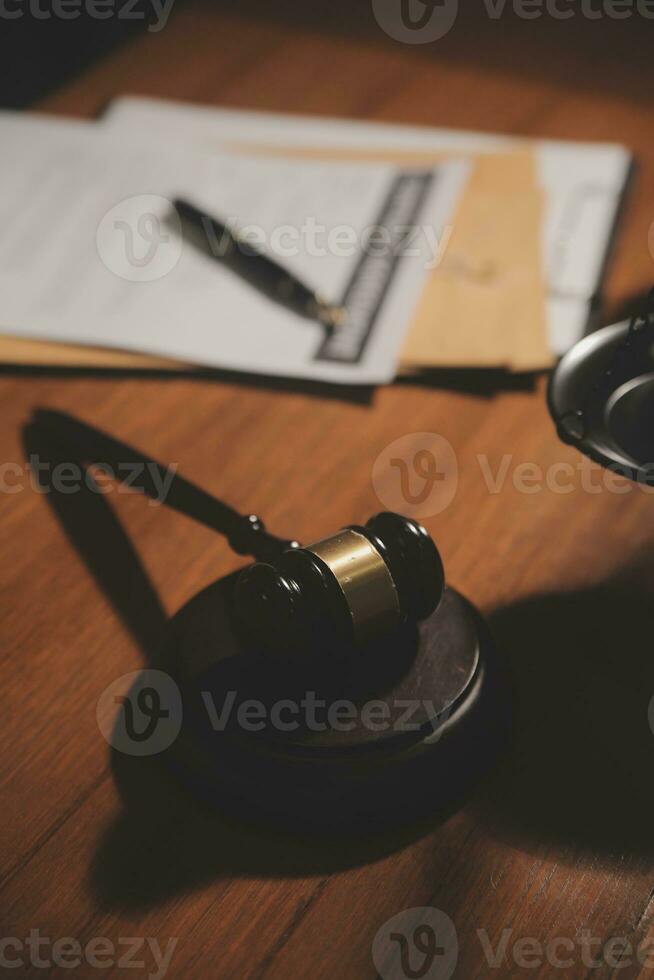 Business and lawyers discussing contract papers with brass scale on desk in office. Law, legal services, advice, justice and law concept picture with film grain effect photo