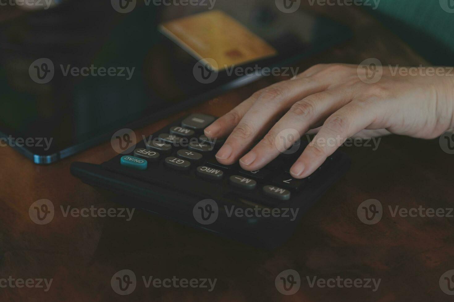 Close up businessman hand using calculator and working with laptop calculate about finance accounting at coffeeshop outdor.finance accounting concept photo