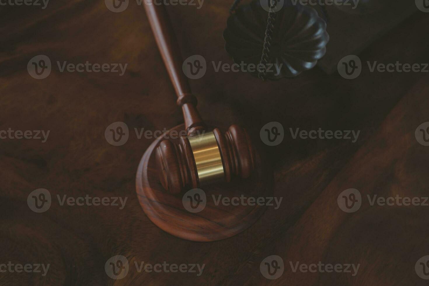 Justice and law concept.Male judge in a courtroom with the gavel, working with, computer and docking keyboard, eyeglasses, on table in morning light photo