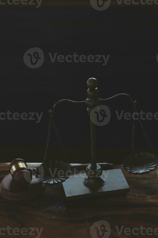 Justice and law concept.Male judge in a courtroom with the gavel, working with, computer and docking keyboard, eyeglasses, on table in morning light photo