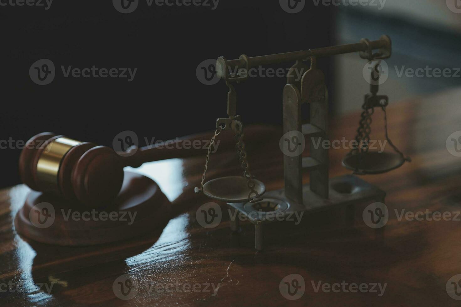 Justice and law concept.Male judge in a courtroom with the gavel, working with, computer and docking keyboard, eyeglasses, on table in morning light photo