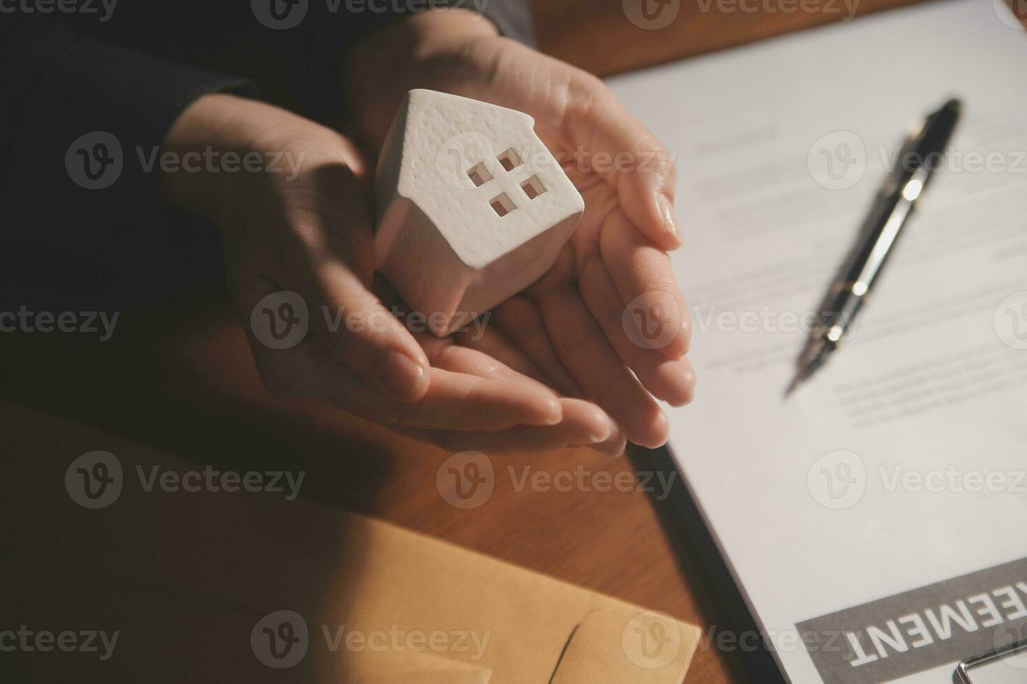 Real estate broker agent presenting and consult to customer to decision making sign insurance form agreement, buy and sell home model, concerning mortgage loan offer for and house insurance photo