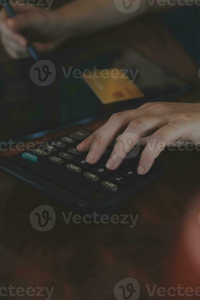 Close up businessman hand using calculator and working with laptop calculate about finance accounting at coffeeshop outdor.finance accounting concept photo