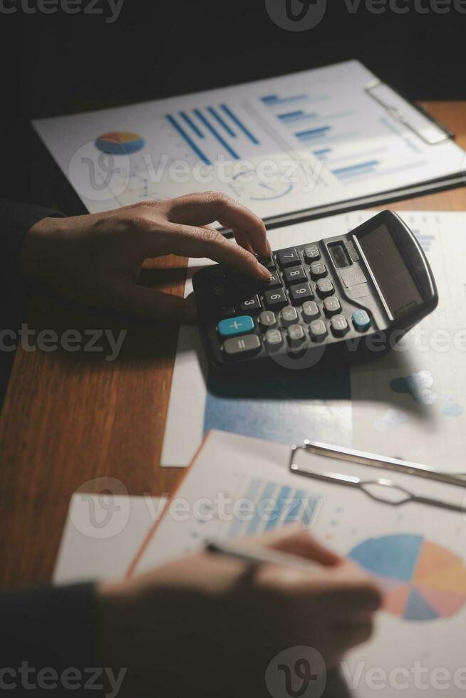 Close up businessman hand using calculator and working with laptop calculate about finance accounting at coffeeshop outdor.finance accounting concept photo