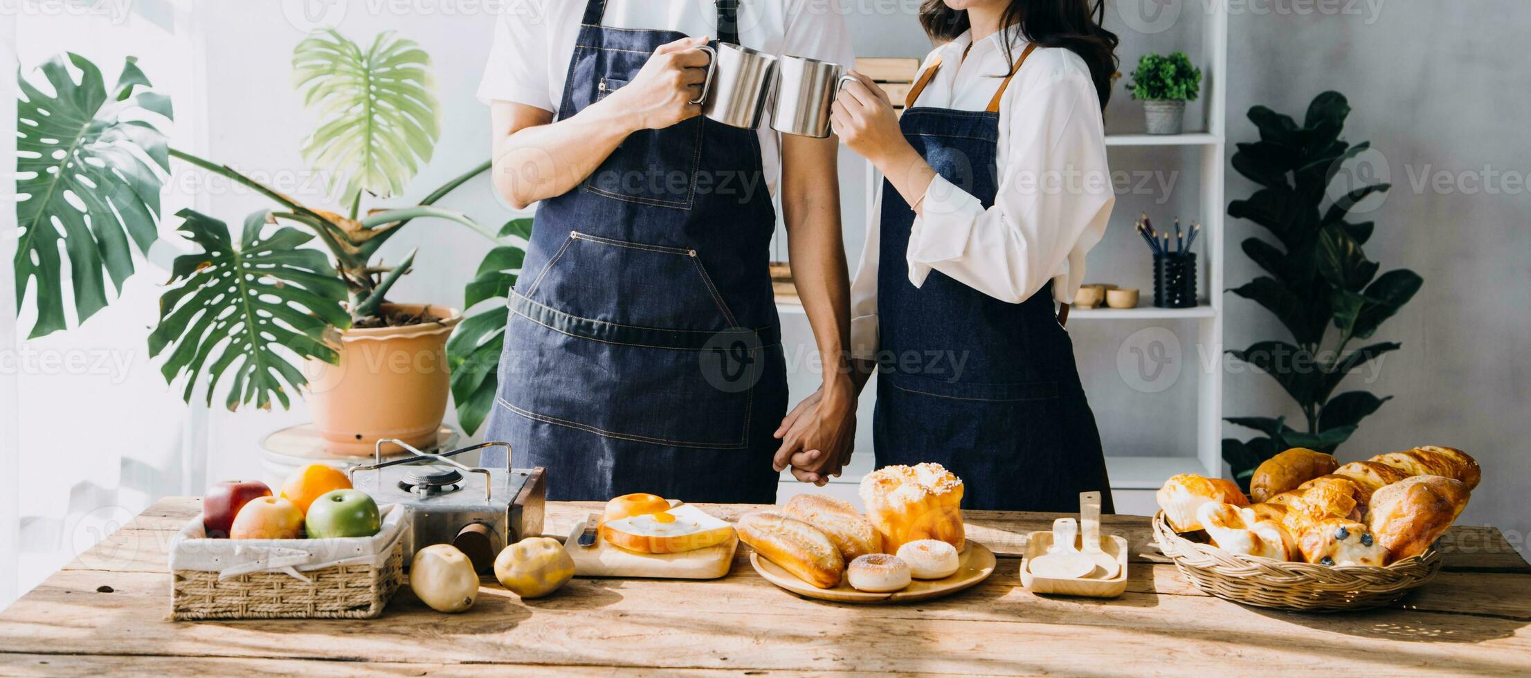 Happy young adult couple making breakfast and drinking coffee together in cozy home kitchen in morning at home. Preparing meal and smiling. Lifestyle, leisure and Love concept. photo