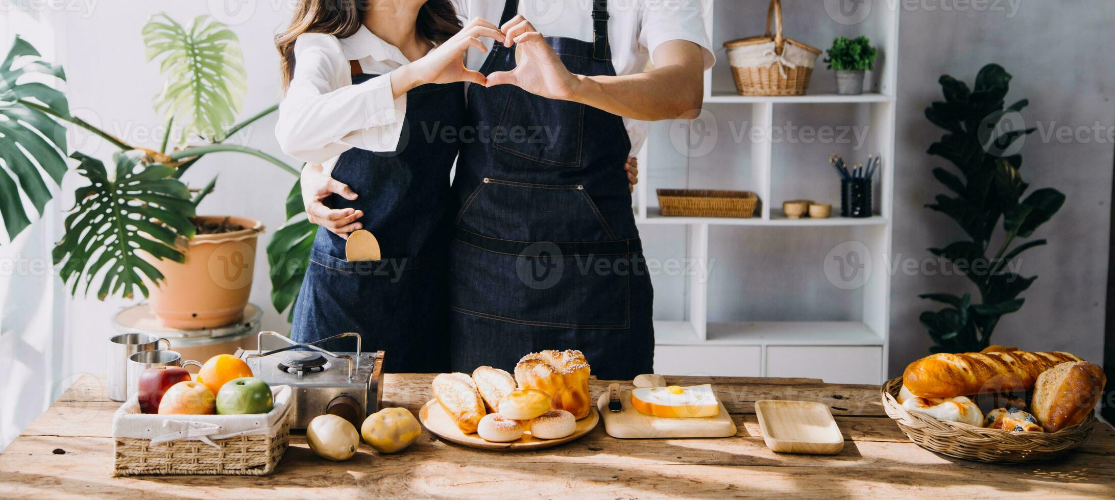 Happy young adult couple making breakfast and drinking coffee together in cozy home kitchen in morning at home. Preparing meal and smiling. Lifestyle, leisure and Love concept. photo