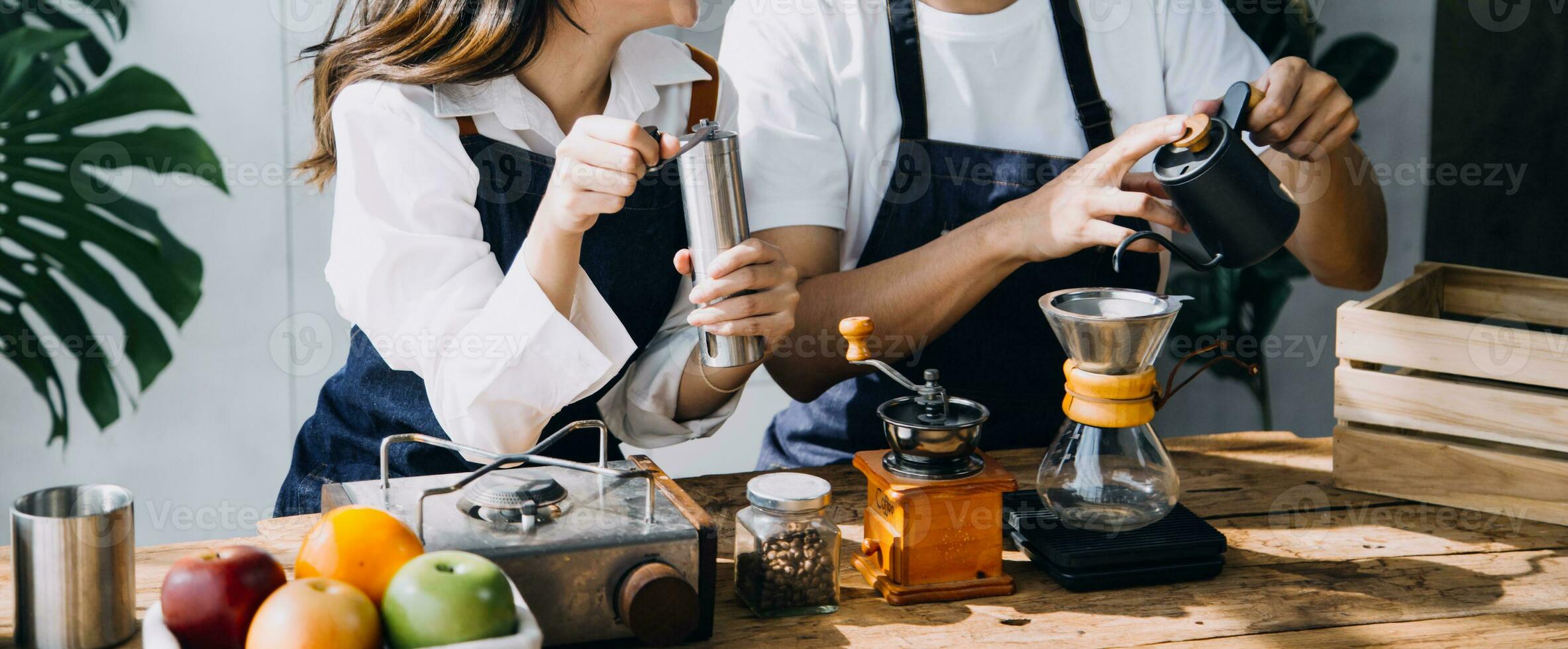 Happy young adult couple making breakfast and drinking coffee together in cozy home kitchen in morning at home. Preparing meal and smiling. Lifestyle, leisure and Love concept. photo