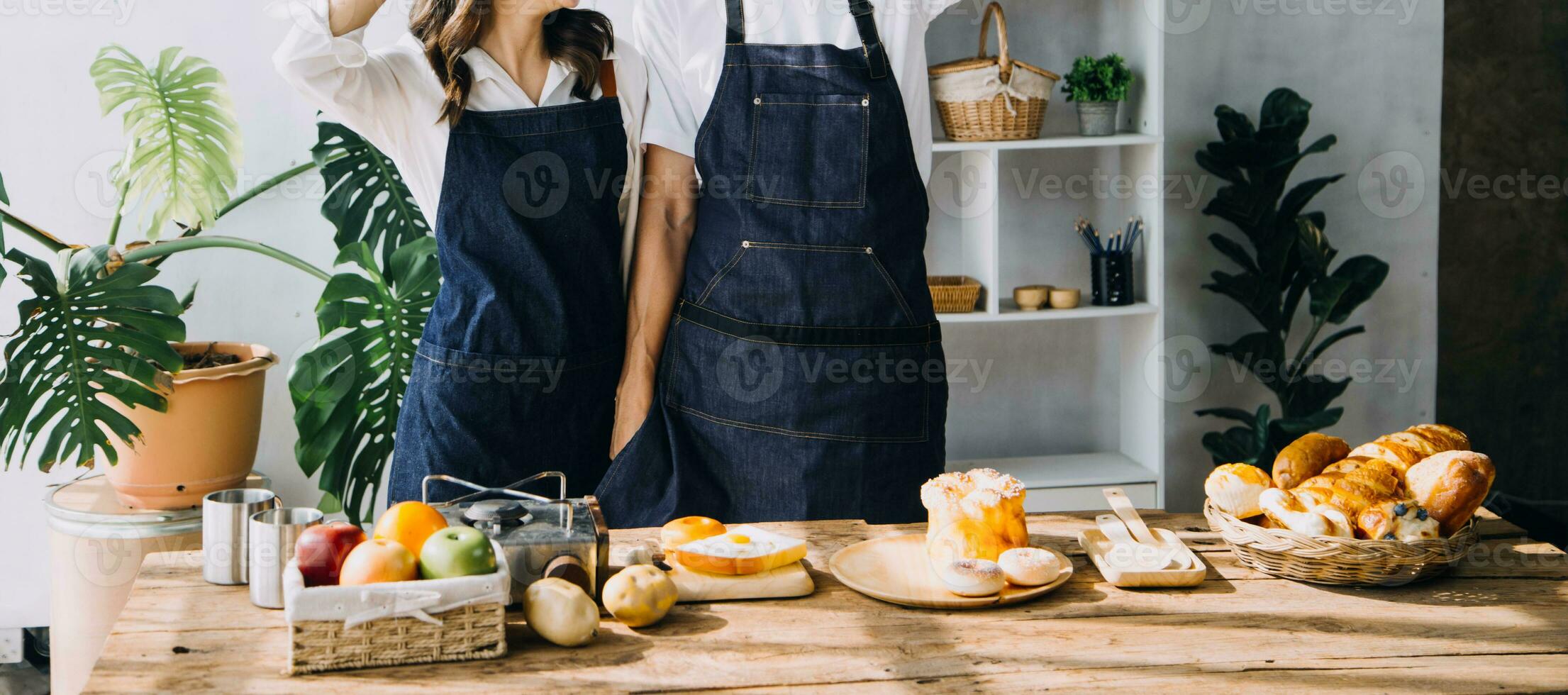 Happy young adult couple making breakfast and drinking coffee together in cozy home kitchen in morning at home. Preparing meal and smiling. Lifestyle, leisure and Love concept. photo