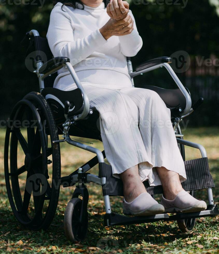 Asian young woman nurse at nursing home take care disabled senior man. Caregiver doctor serve physical therapy for older elderly patient to exercise and practice walking on walker or cane at backyard. photo