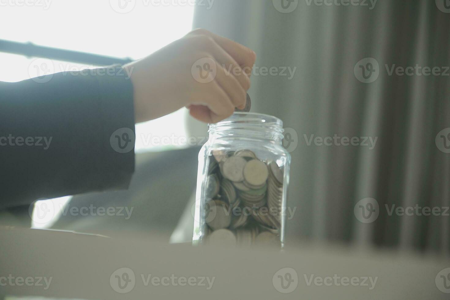 saving money and accounting concept. business man putting coin insert to jar and make acounting book for finance management to investment and saving. photo