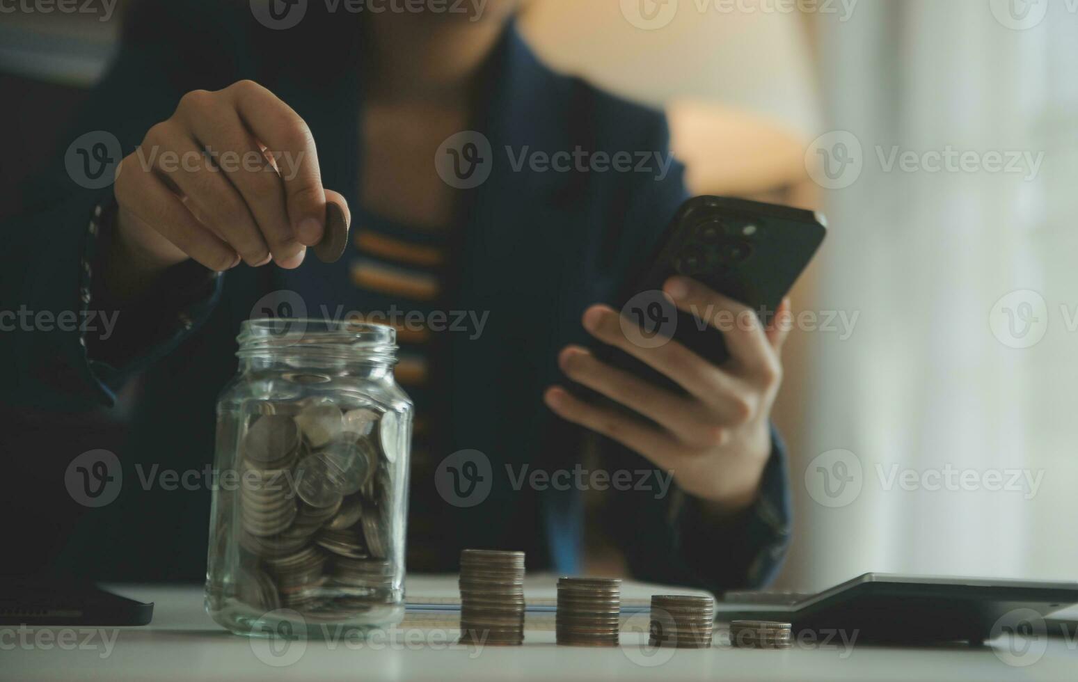 saving money and accounting concept. business man putting coin insert to jar and make acounting book for finance management to investment and saving. photo