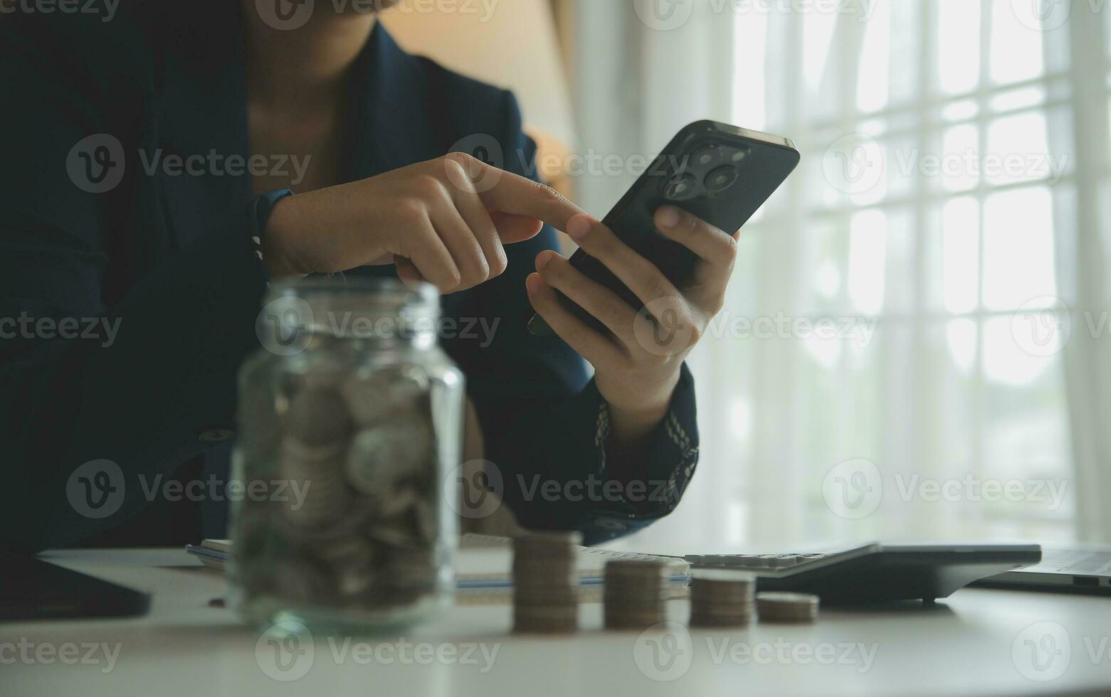 saving money and accounting concept. business man putting coin insert to jar and make acounting book for finance management to investment and saving. photo