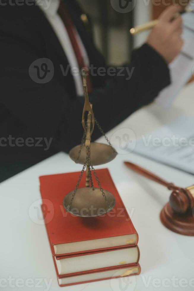 Business and lawyers discussing contract papers with brass scale on desk in office. Law, legal services, advice, justice and law concept picture with film grain effect photo