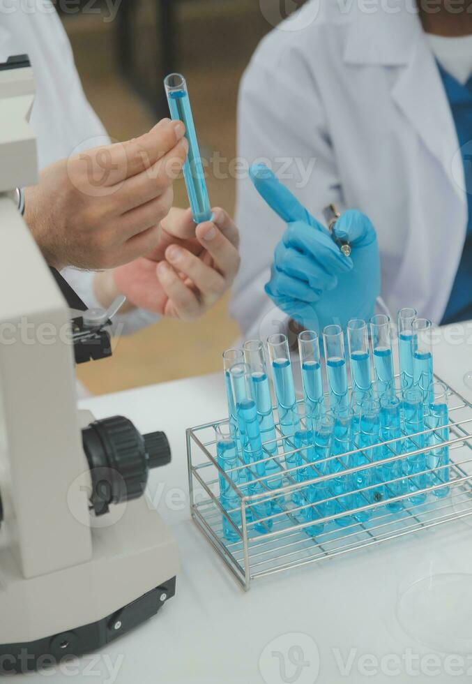 Scientist or medical in lab coat working in biotechnological laboratory, Microscope equipment for research with mixing reagents in glass flask in clinical laboratory. photo