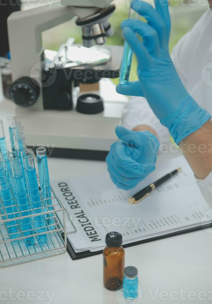 Scientist or medical in lab coat working in biotechnological laboratory, Microscope equipment for research with mixing reagents in glass flask in clinical laboratory. photo