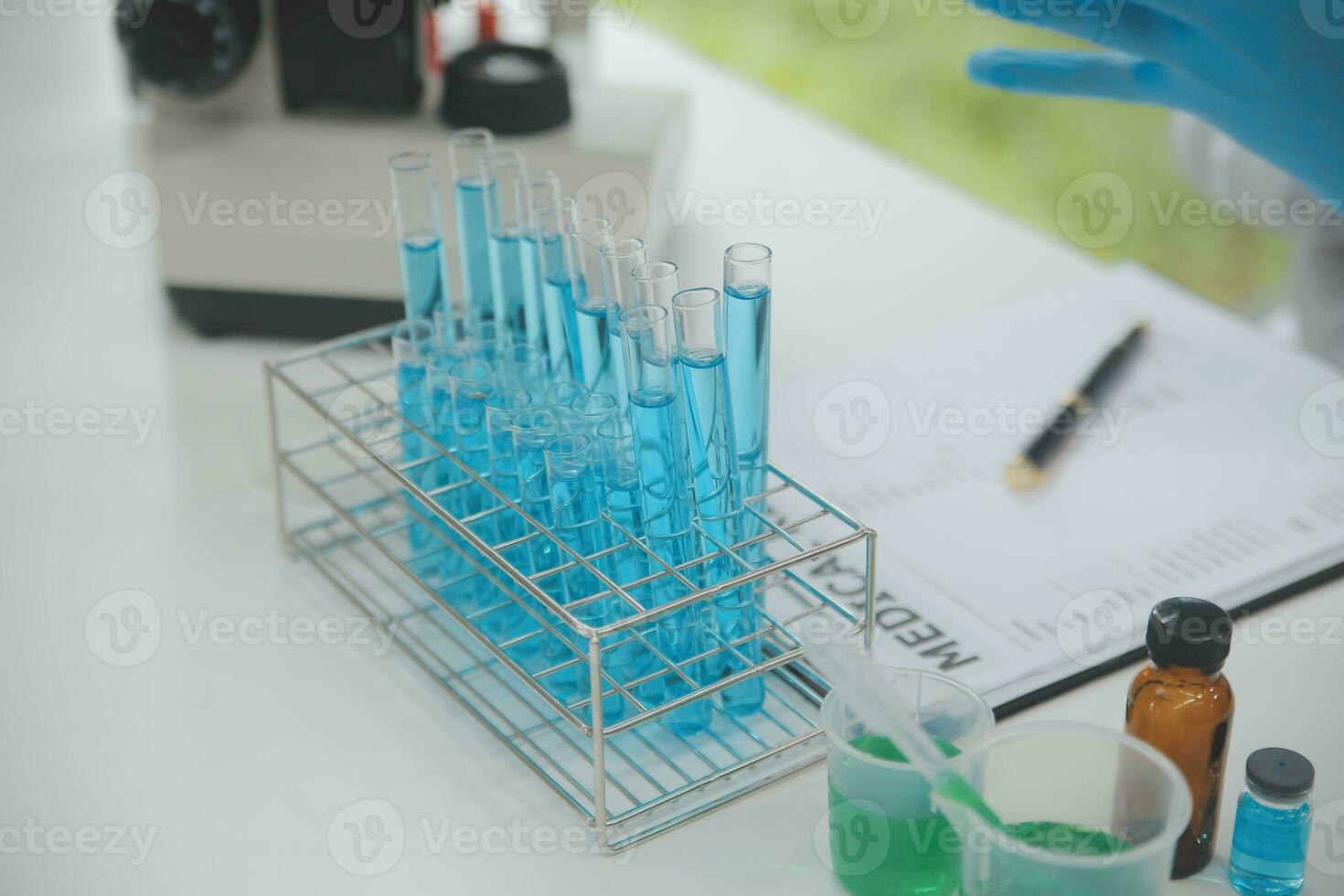 Scientist or medical in lab coat working in biotechnological laboratory, Microscope equipment for research with mixing reagents in glass flask in clinical laboratory. photo