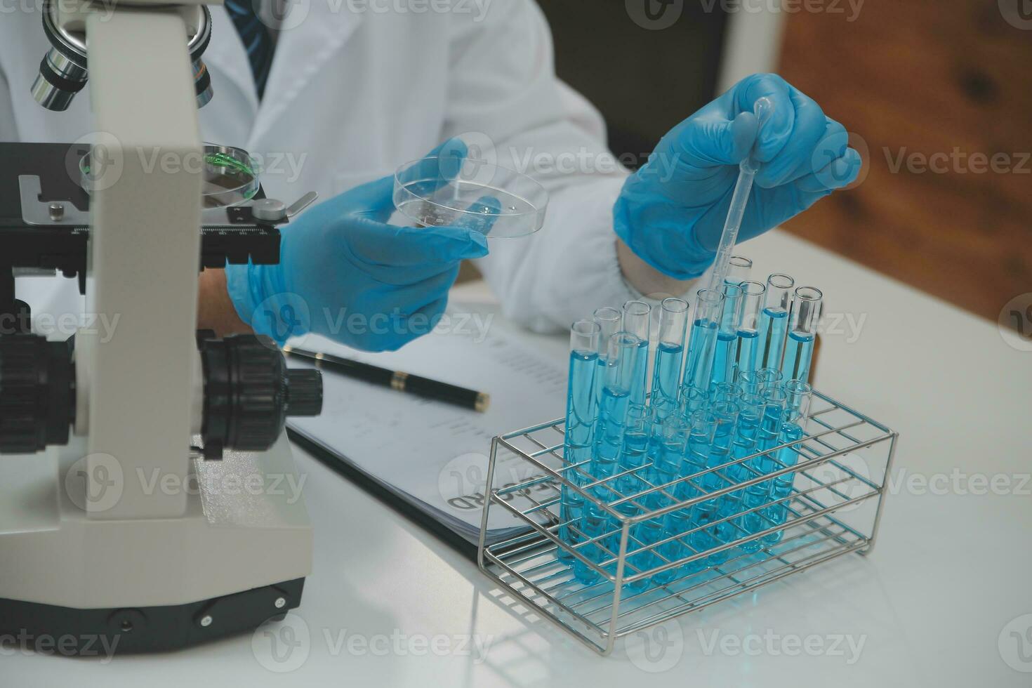 Scientist or medical in lab coat working in biotechnological laboratory, Microscope equipment for research with mixing reagents in glass flask in clinical laboratory. photo