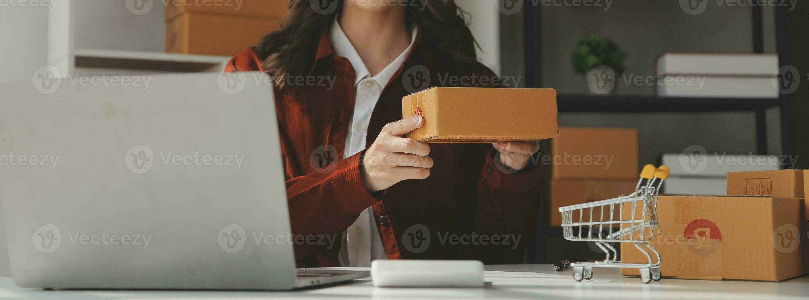 Portrait young attractive hipster asia female owner startup look at camera work happy with box at home prepare parcel delivery in sme supply chain, procurement, omnichannel ecommerce online concept. photo