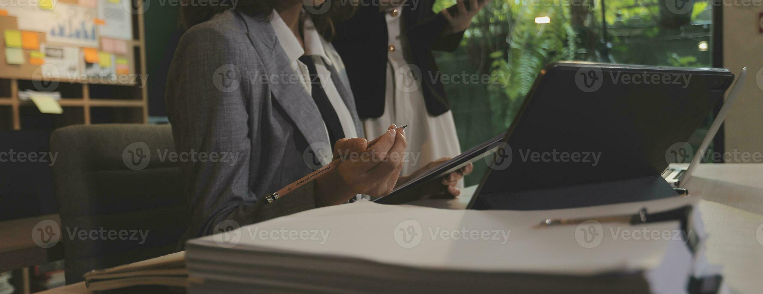 Entrepreneur Asian businessman and businesswoman discussing new business project in tablet in modern Meeting In Modern Office, Asian business casual concept. photo
