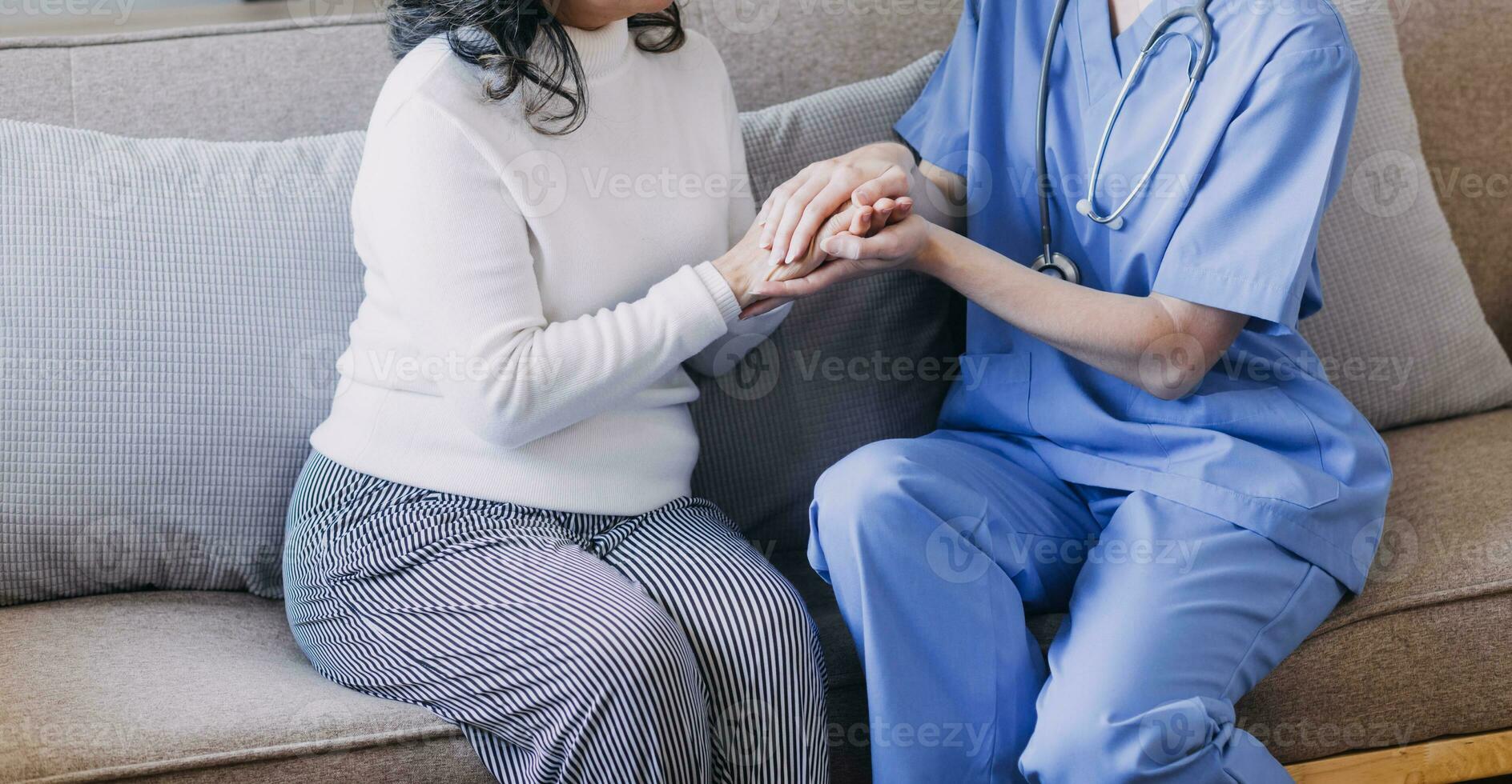 Homecare nursing service and elderly people cardiology healthcare. Close up of young hispanic female doctor nurse check mature caucasian man patient heartbeat using stethoscope during visit photo